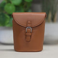 Brown leather pouch with a buckle on a blurred background