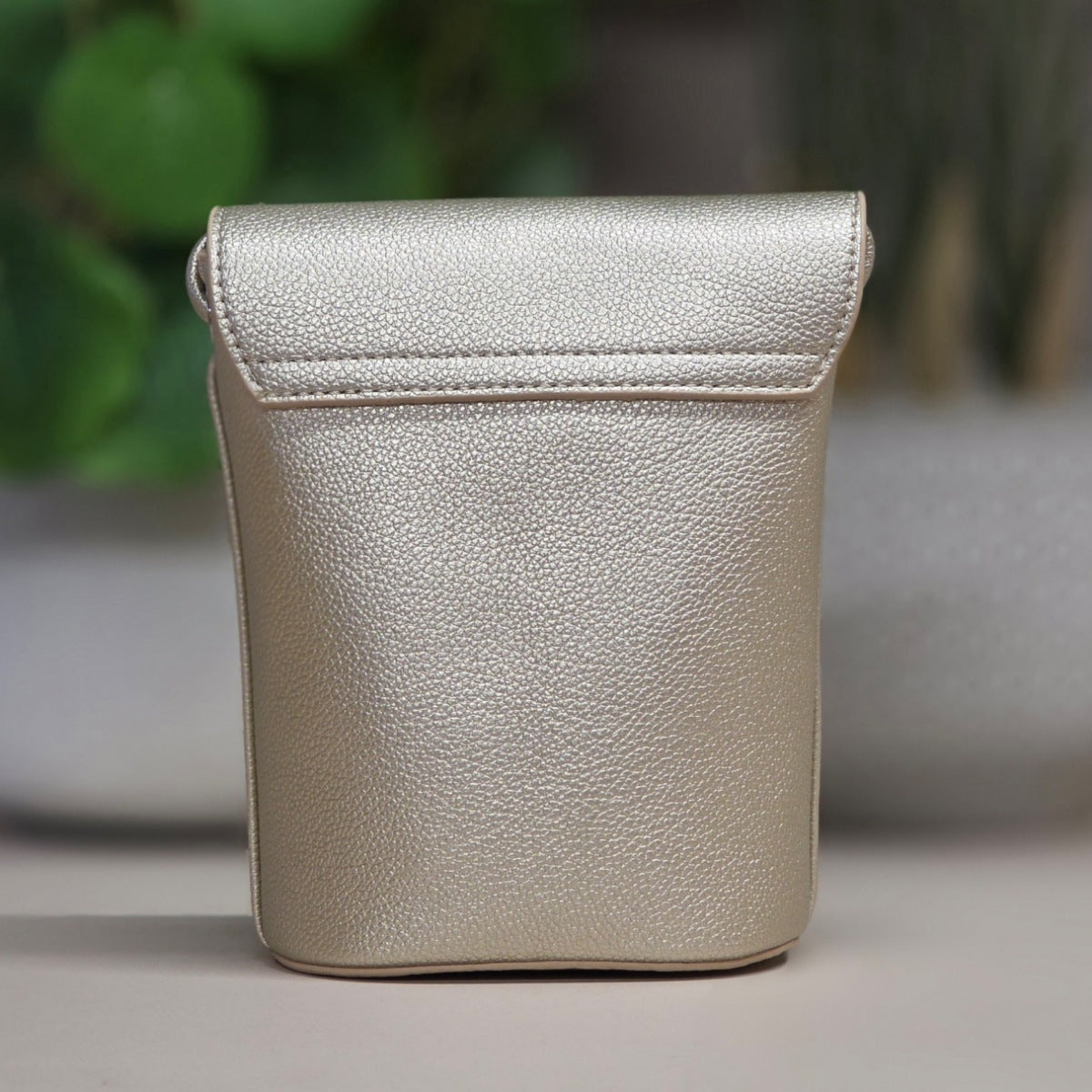 Gold leather pouch on a neutral background