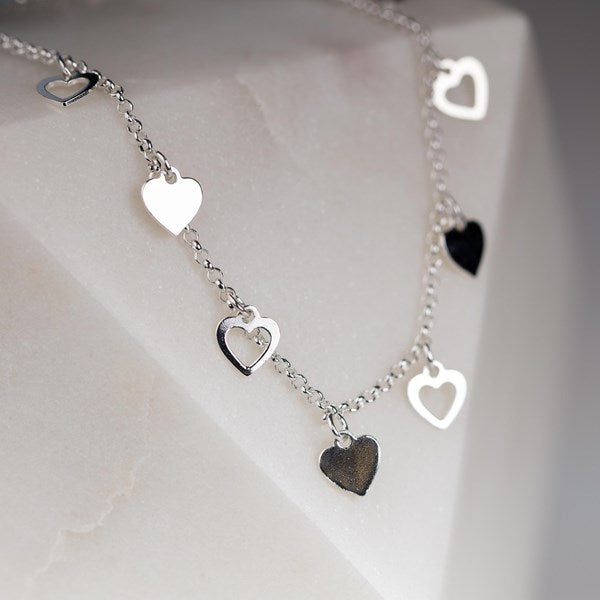 Silver heart-shaped bracelet on a light background