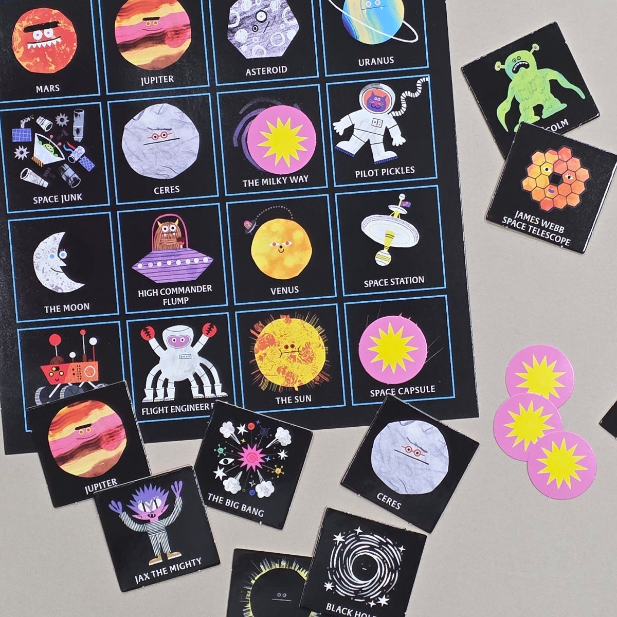 Educational space-themed cards on ae surface with colourful stickers.