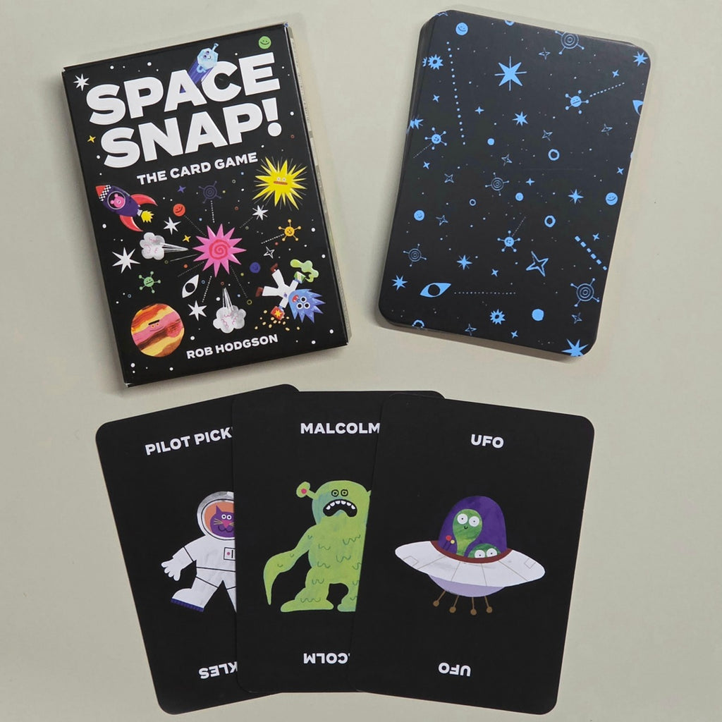 Space Snap card game set with the main box, the back of the card deck, and three sample cards showing space-themed illustrations on a light grey background.