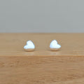 Heart-shaped earrings on a wooden surface with a gray background
