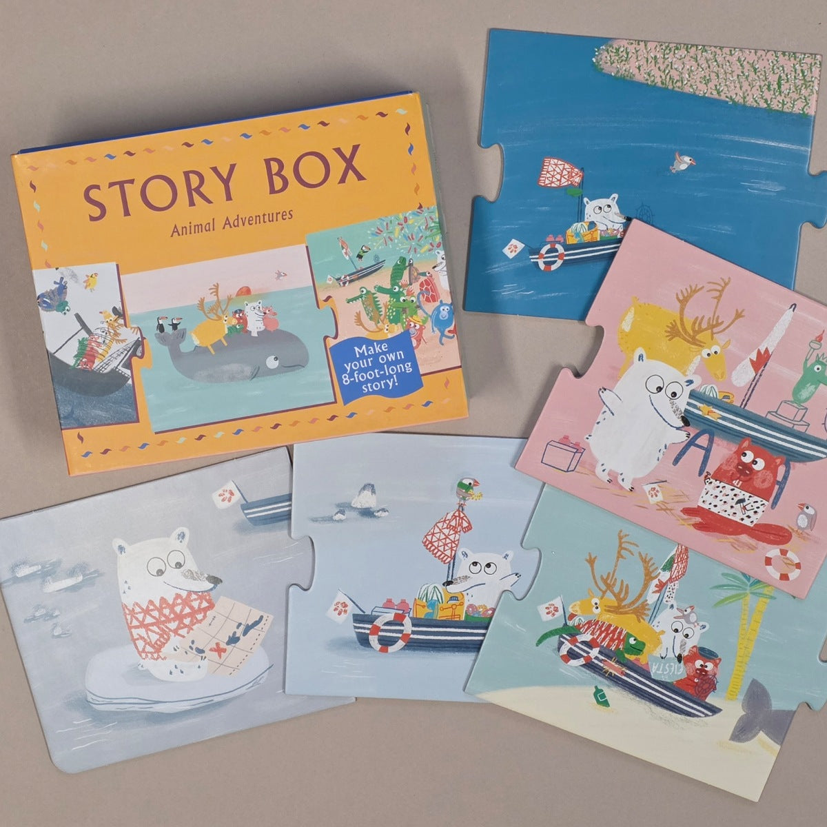 A children's jigsaw puzzle set titled 'STORY BOX' arranged on a neutral beige surface. The set includes a colourful illustrated box and several puzzle pieces showing animal adventure scenes on the ocean.