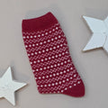 Red knitted sock with white pattern on a light grey background