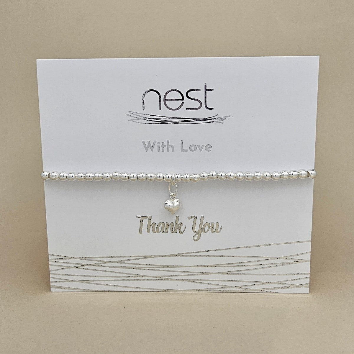 Bracelet on a 'nest' branded card with 'Thank You' text on a beige background