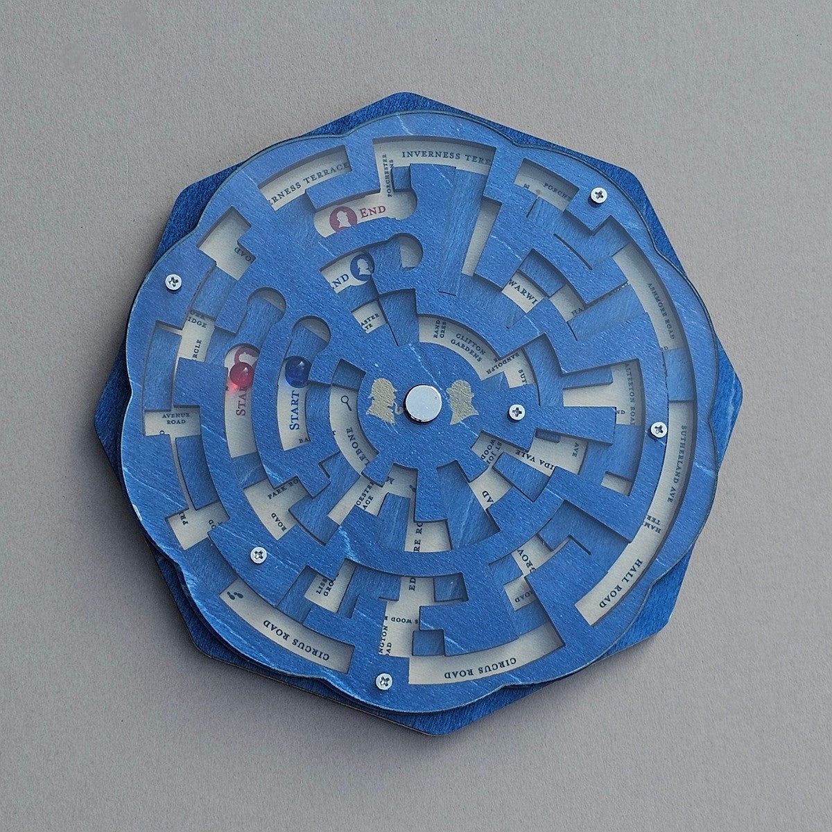 Blue mechanical puzzle with circular design on a grey background