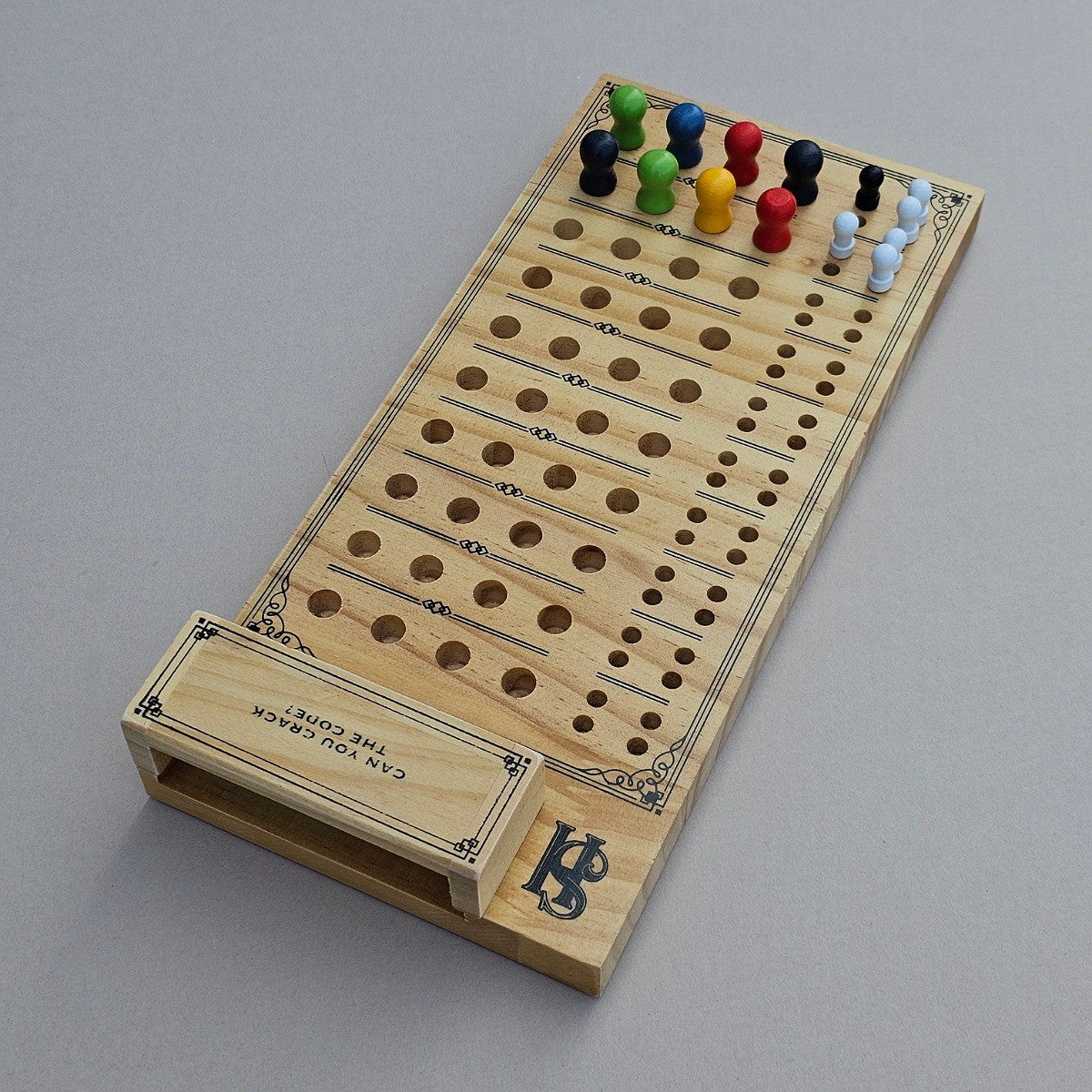 Wooden cribbage board with pegs on a grey background
