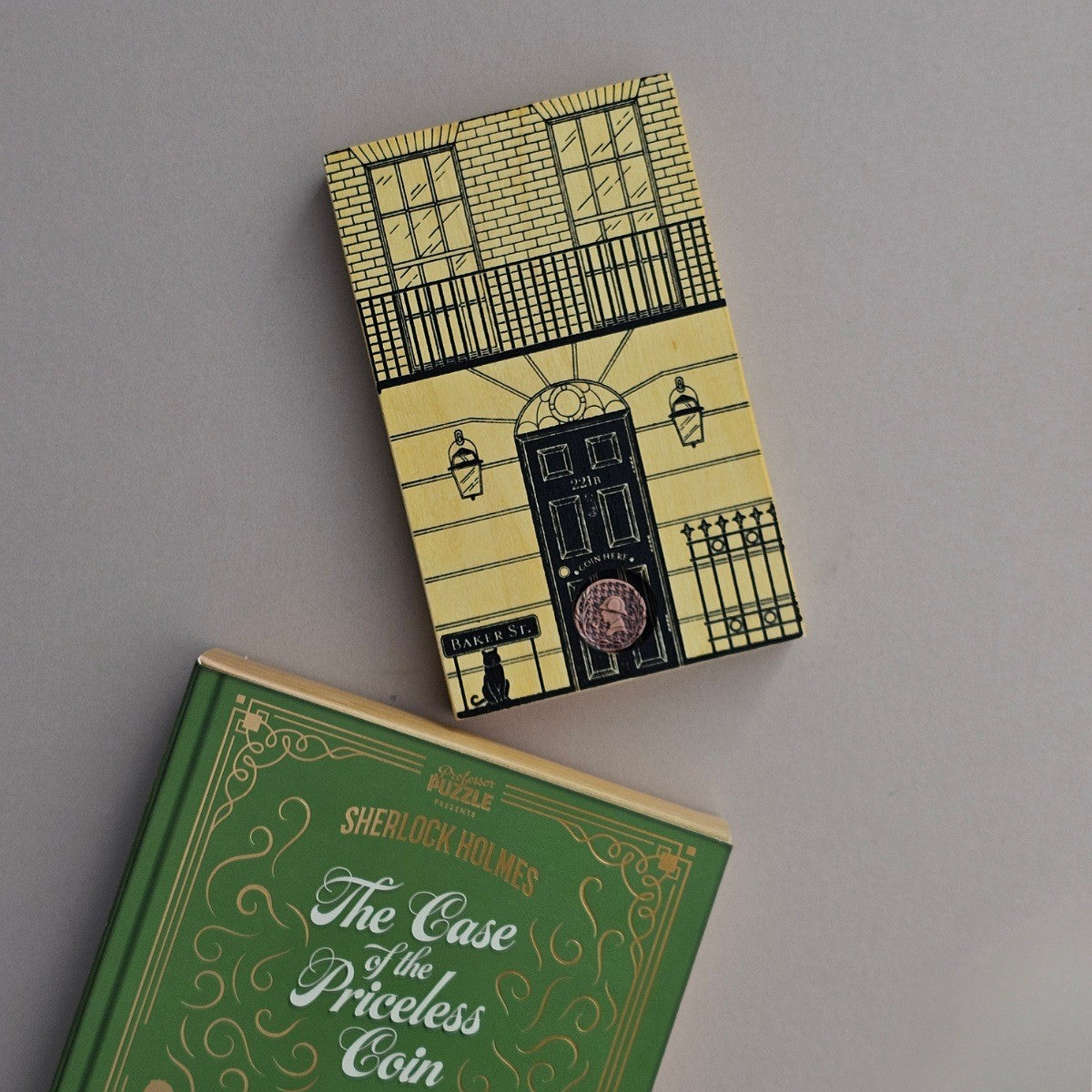 Two boxes with decorative covers stating 'The case of the priceless coin' and 'Baker Street' on a grey background