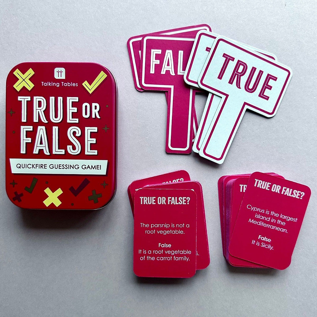 A 'True or False' quickfire guessing game set, featuring a red tin box, pink and white true/false sign cards, and pink question cards on a neutral gray background.